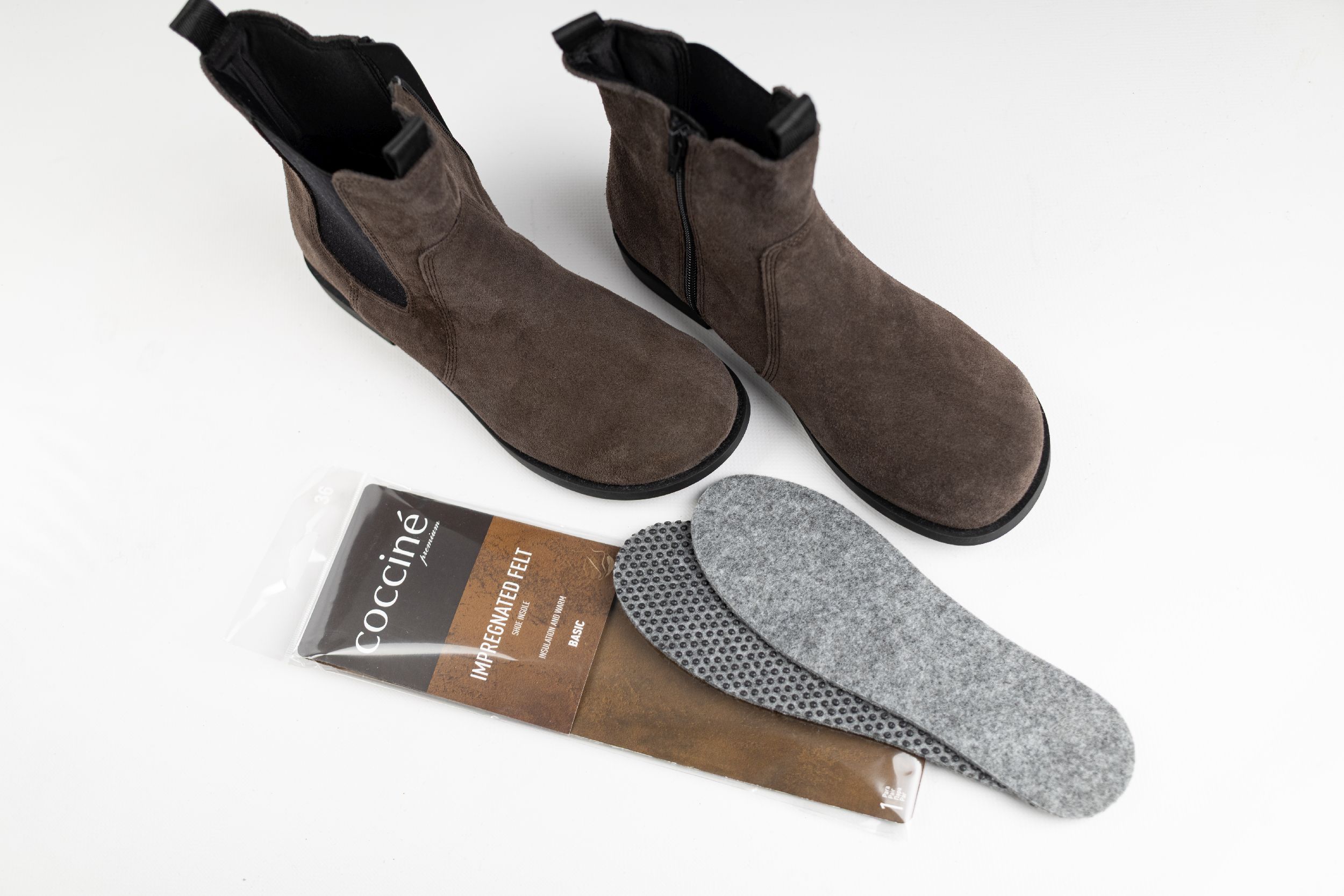 Wkładki do butów z filcu Coccine obok damskiego obuwia